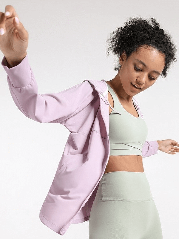 Woman wearing a light purple sports jacket with hood, showcasing activewear ideal for jogging, running, and yoga. Comfortable and stylish.